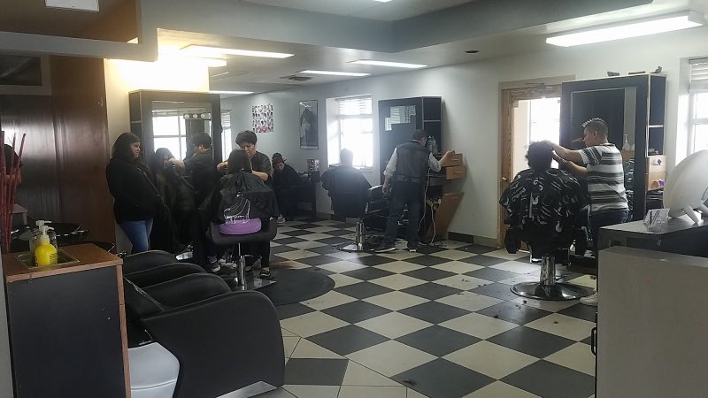 Interior of Salon De Belleza Lily with checkered floor and stylists working with clients